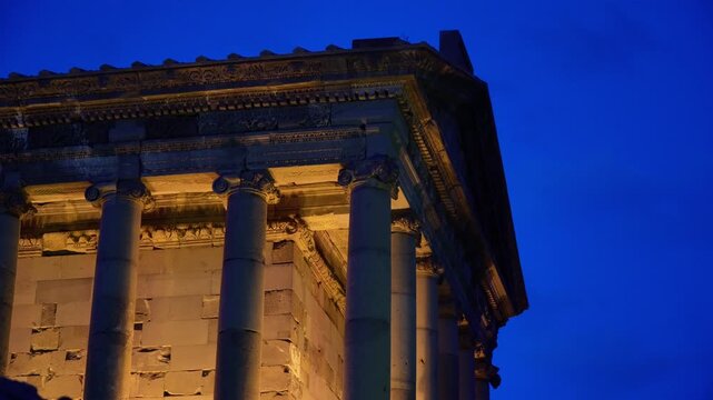 Side view detail of Garni Temple carvings illuminated at dusk in Armenia