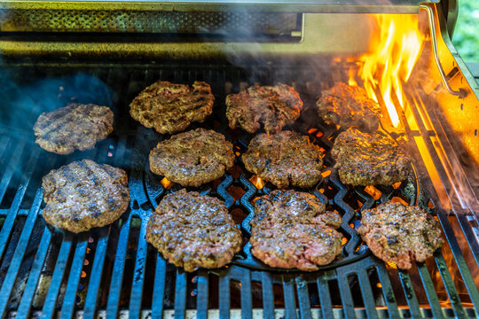 Durchgebratene Burger Hamburger auf einem Grill mit Flammen 