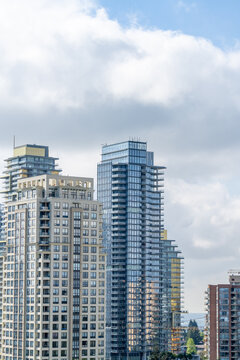 Contemporary high-rise apartment towers with glass facades under cloudy sky