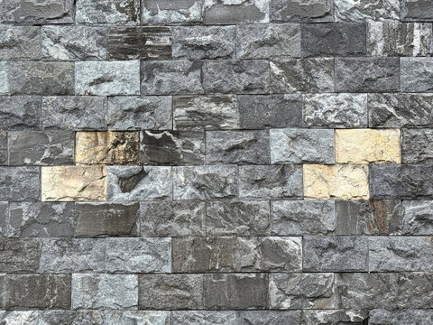 Close up of rough 3D andesite slate stone or grey paving stone. Suitable for wall finishes, cladding, or outdoor floor materials. Mix grey and beige color Seamless background texture.