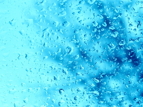 Rain water drops on blue window glass background