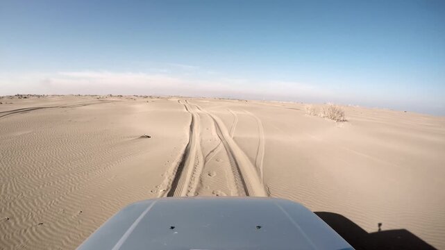 Desert vehicle stuck deep in soft sand as 4x4 offroad tracks vanish across a closed route. Bogged suv trapped on arid dunes remote overland travel failure impassable trail ahead.