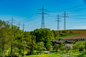 Obraz premium Hochspannungsmasten im Feld