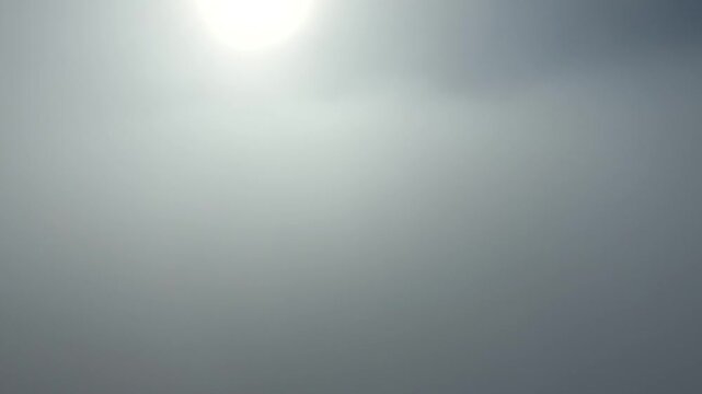 Vertical camera rises through dense fog and breaks above clouds symbolizing freedom and discovery. Cinematic ascent shows sense liberation, open sky, and sky calm plus calm sky plus sky reveal.