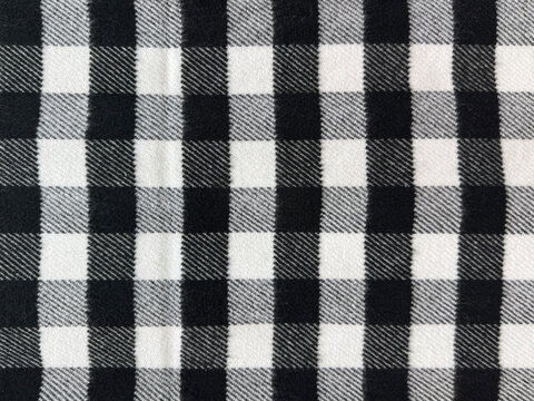 Close up of fabric with tartan pattern. In black and white color. Flannel or tartan style is very common in scarf, shirts, and fashion industry. Seamless background texture.