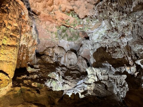Magnificent cave walls and ceiling texture displaying stalactites and stalagmites with karst and natural limestone rock formations carved by nature.