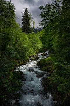 mountain river in the forest with dramatic cloudy sky. Ariege Pyrenees France
