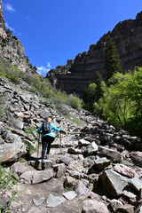 Naklejka premium Woman hiking on Hanging Lake Trail in White River National Forest in Glenwood Canyon, Colorado on clear sunny spring day.