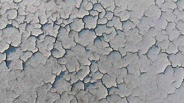 Fissures across cracked dry soil surface show severe drought and erosion patterns clearly. Close view emphasizes aridity hardened crust polygon cracks climate stress on ground.