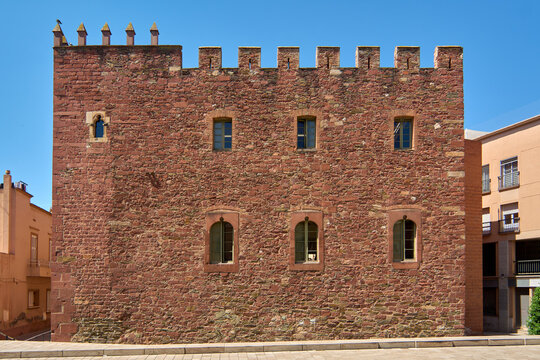 Architectural detail of the Torre del Baro monument, featuring historic battlements and Gothic-style windows on a sunlit afternoon in the Mediterranean.