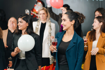 Naklejka premium Party celebration group of adult people holding balloon and glass in indoor event, smiling social gathering with festive mood