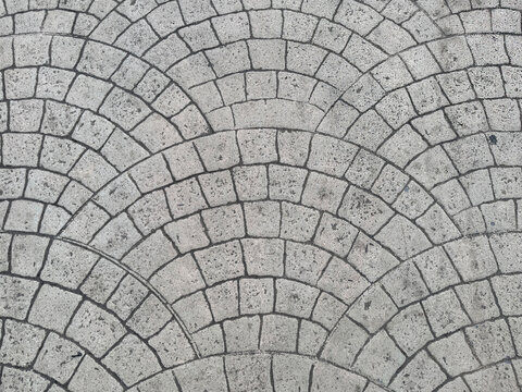 Close up of round fan shaped paving stone in arched or curved fan pattern. Suitable for pavement or sidewalk floor, for a vintage, classic, or European outdoor. Seamless background texture.