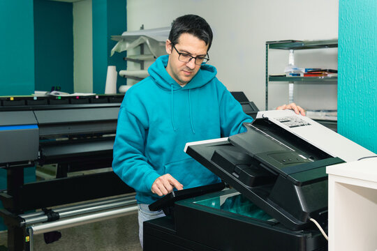 Man operating multifunctional office printer scanner machine