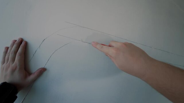 Scoring curved lines on wall surface with cutting tool