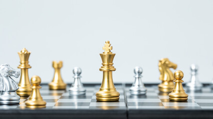 Gold and silver chess pieces on chessboard with king in focus © PhamHong