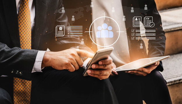 Two business professionals collaborate using a smartphone and tablet, surrounded by digital graphics representing teamwork and data in a modern work environment. Cyphers
