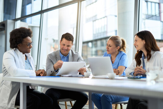 Happy mid adult businessman having a meeting with group of doctors at the clinic.