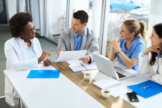 Happy mid adult businessman having a meeting with group of doctors in hospital