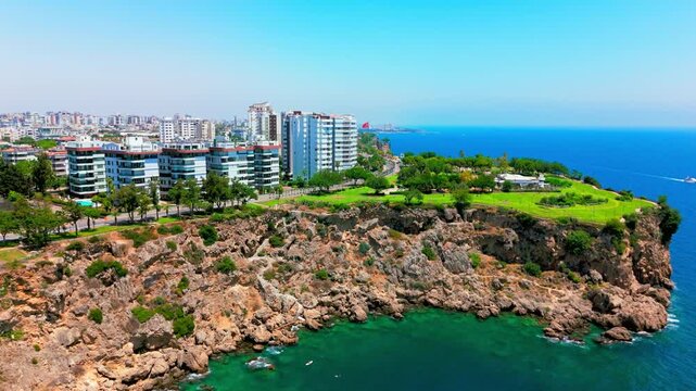 Prominent group of mid-rise and high-rise apartment blocks set back from the cliffs on a green plateau, near Lower Düden Waterfalls, Antalya, Turkey.