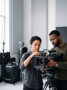 Professional Film Crew Setting Up a Cinema Camera in a Studio