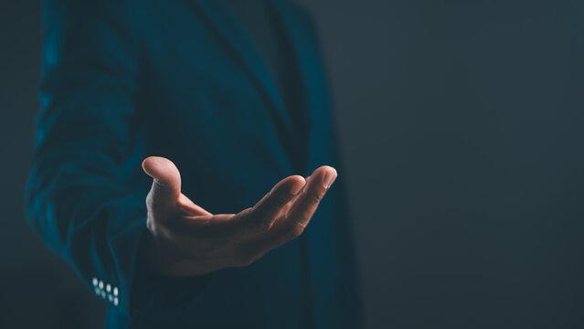 A close-up of a person's hand extended forward, against a dark background, symbolizing offering, help, or invitation.