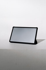 Minimalist tablet on white surface with soft shadow in studio lighting © febdwithart