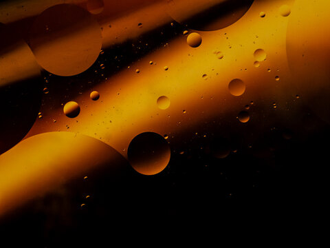 Luxury golden oil bubbles macro background, premium cosmetic liquid texture, elegant black and gold abstract fluid