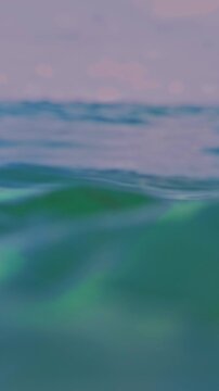 Vertical video. First Person View Of Ocean Waves Rolling Toward Camera At Water Level With Soft Focus Horizon And Gentle Motion, Calm Sea Atmosphere