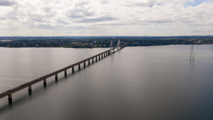 Fototapeta premium Distant view of the Roque Gonzalez Bridge spanning the Parana River with Encarnacion city skyline on the horizon.