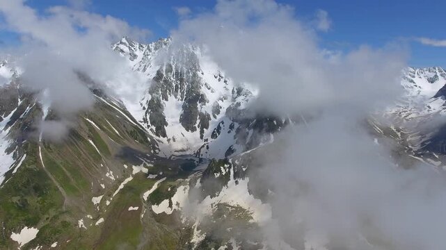 Aerial Alps Europe alpine lake below snowy peaks creates a pristine wilderness view. Calm water, glacial walls, and mirrorlike surface frame serene uplands across isolated terrain.