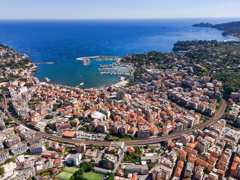 Aerial view of the coastal town of Rapallo featuring the harbor, colorful buildings, and railway line along the Mediterranean coast in Rapallo, Liguria, Italy.