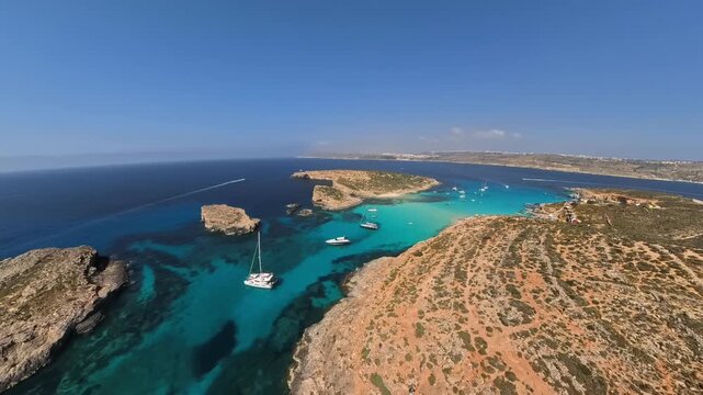 Wide, panoramic, aerial shot of Comino island and Blue Lagoon from a drone flying backward