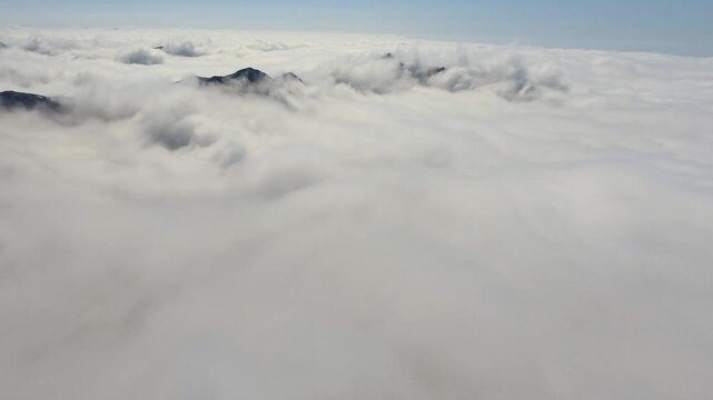 High Atlas Morocco mountain peaks rise above clouds with rugged ridges and high altitude drama. Misty layers, vapor flow, elevated relief create striking atmospheric scenery across remote ranges.