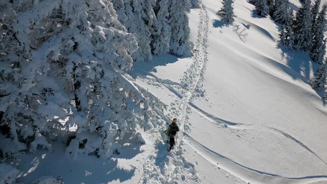 hombre caminando en la nieve con tabla de snowboard