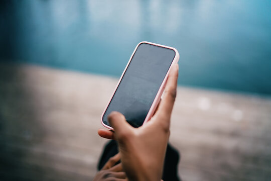 Close up of hand holding smartphone with blank screen, mobile phone application mockup, person using cellphone outdoors, digital technology, 5G internet, connection, copy space.