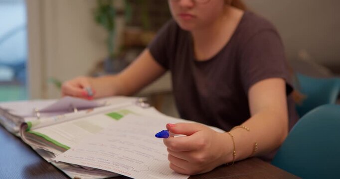 Student's Deep Study: A young student, lost in focused concentration, delves into their studies at a desk filled with notebooks and handwritten notes, capturing a moment of academic dedication.