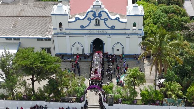 Church in Central America with people celebrating Easter.
Aerial drone footage of Parroquia Inmaculada Concepci&oacute;n de Ataco; Semana Santa Easter procession in Concepci&oacute;n de Ataco, El Salvador.