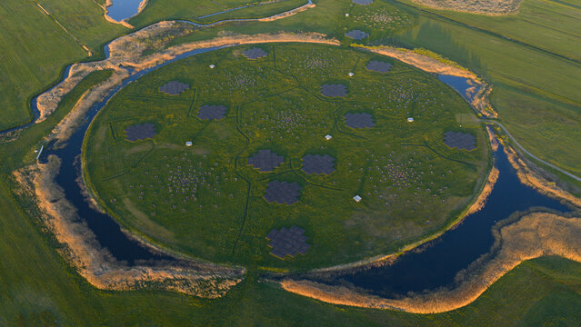 Aerial view of the LOFAR superterp radio telescope station with its circular island and antenna arrays surrounded by water channels in Buinen, Drenthe, Netherlands.