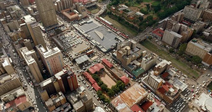4K drone flyover above a typical Johannesburg district in South Africa. Aerial view of city traffic, busy streets, and dense urban architecture within the metropolitan residential area