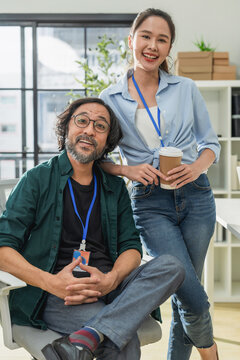 Portrait of professional Asian business team in modern office, happy coworkers smiling and posing at creative workspace