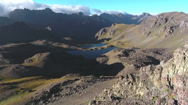 Aerial glacial lakes among barren mountains in eastern Turkey, remote summer highland water. Treeless ridges, clear basins, rugged plateau, open terrain, isolated alpine landscape, stock search.