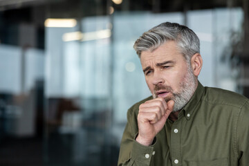 Naklejka premium Mature man coughing feeling unwell with flu symptoms