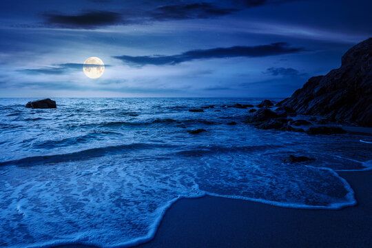 mysterious sandy sea beach at night. full moon over scene on cold summer vacation season. beautiful view of waves washing the sand. generic image of seascape and sky for advertising background