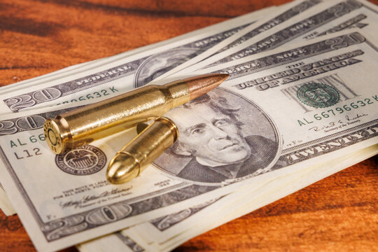 Financial crime concept with twenty dollar bills and bullets on mahogany table representing corruption and illegal business.