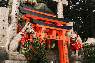 Fototapete Torii Tore Stone Kitsune fox statue guardian with red bib in front of Torii gates, Fushimi Inari Shrine, Kyoto.  © Alex