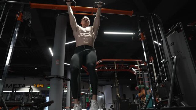 Lifting legs footage. Exercise for abs sixpack torso muscle. Hanging leg raises or man in training. Sporty man training abs. Sixpack exercise by hanging leg raises. Muscular sportsman do abs workout
