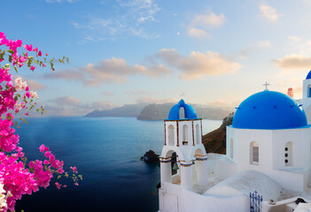 traditional greek village Oia of Santorini, with blue domes of churches in sunset light, Greece © neirfy