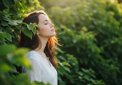 Woman with closed eyes and golden rim light near bushes, peaceful nature portrait for wellness campaigns, mindfulness articles and outdoor lifestyle branding