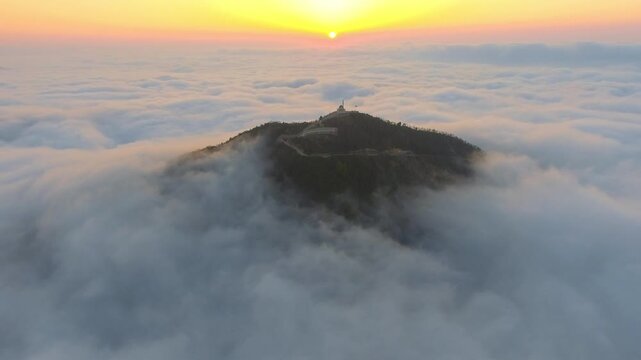 Aerial mosque and minaret above cloud ocean at sunrise during Ramadan, serene prayer scene. Islamic shrine, misty ridge, dawn glow, spiritual worship, tranquil Sufi sanctuary, stock search wording.