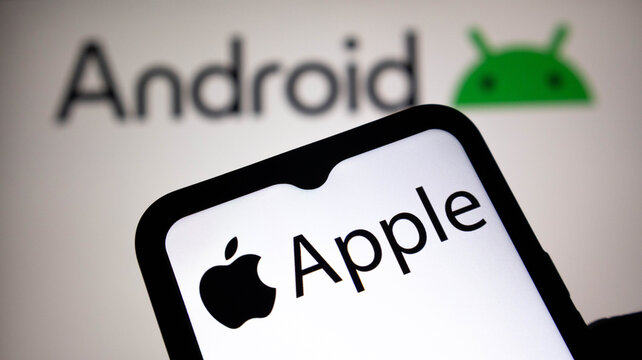 Closeup of a smartphone screen displaying the apple logo and brand name with the android logo and text visible in the blurred background